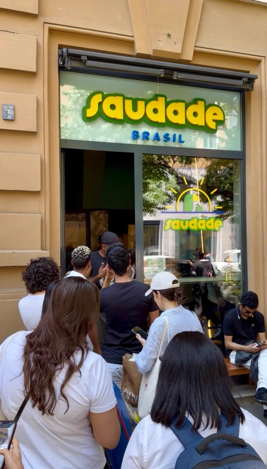 Una piccola folla aspetta davanti a Saudade Brasil